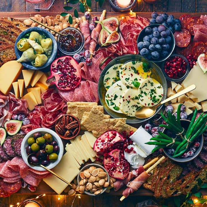 A platter of meats and cheeses on a wooden board.